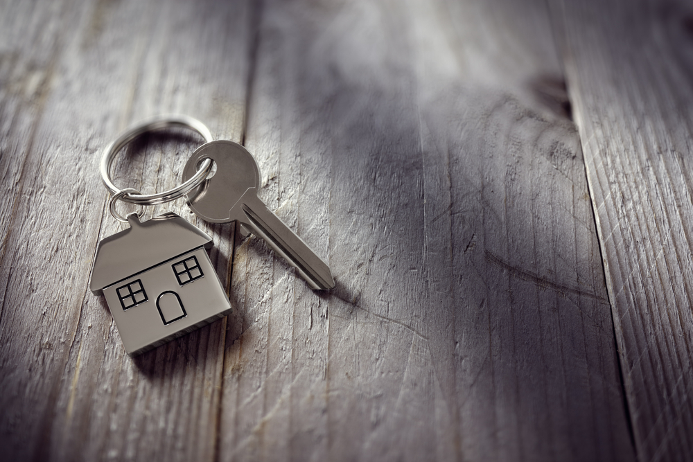 Key with house key ring on grey background
