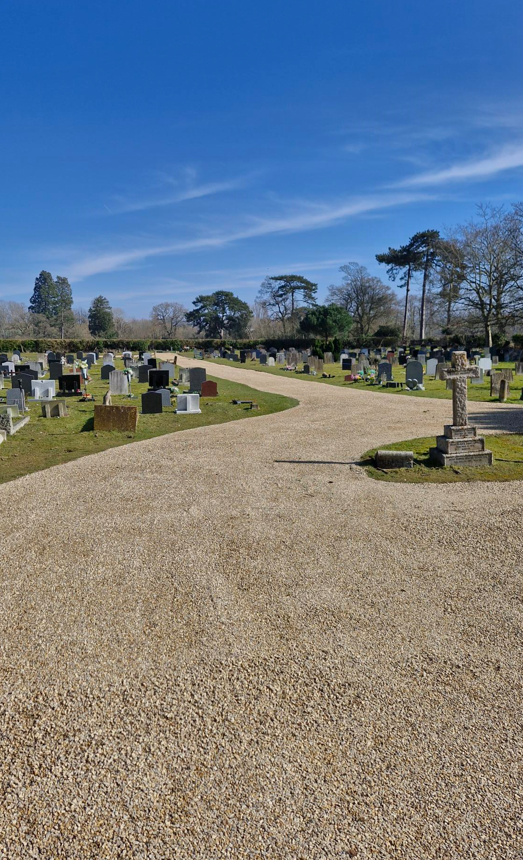 new path running through cemetery with graves either side