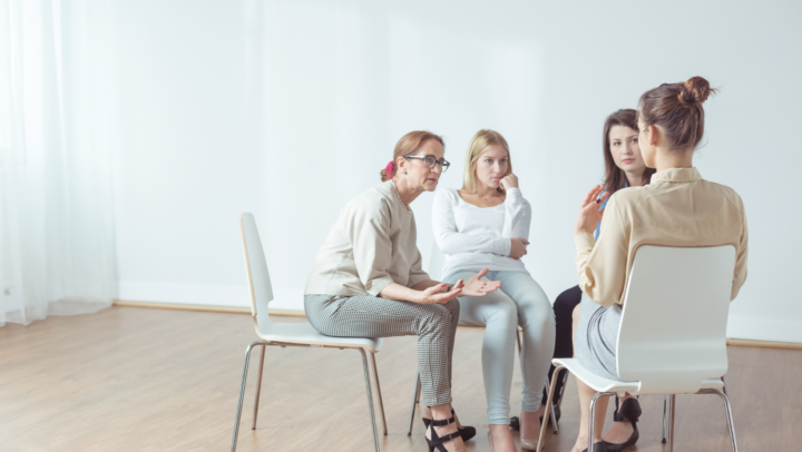 An image of a three girls being supported by an adult