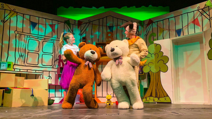Image of two actors performing with bear puppets on stage.